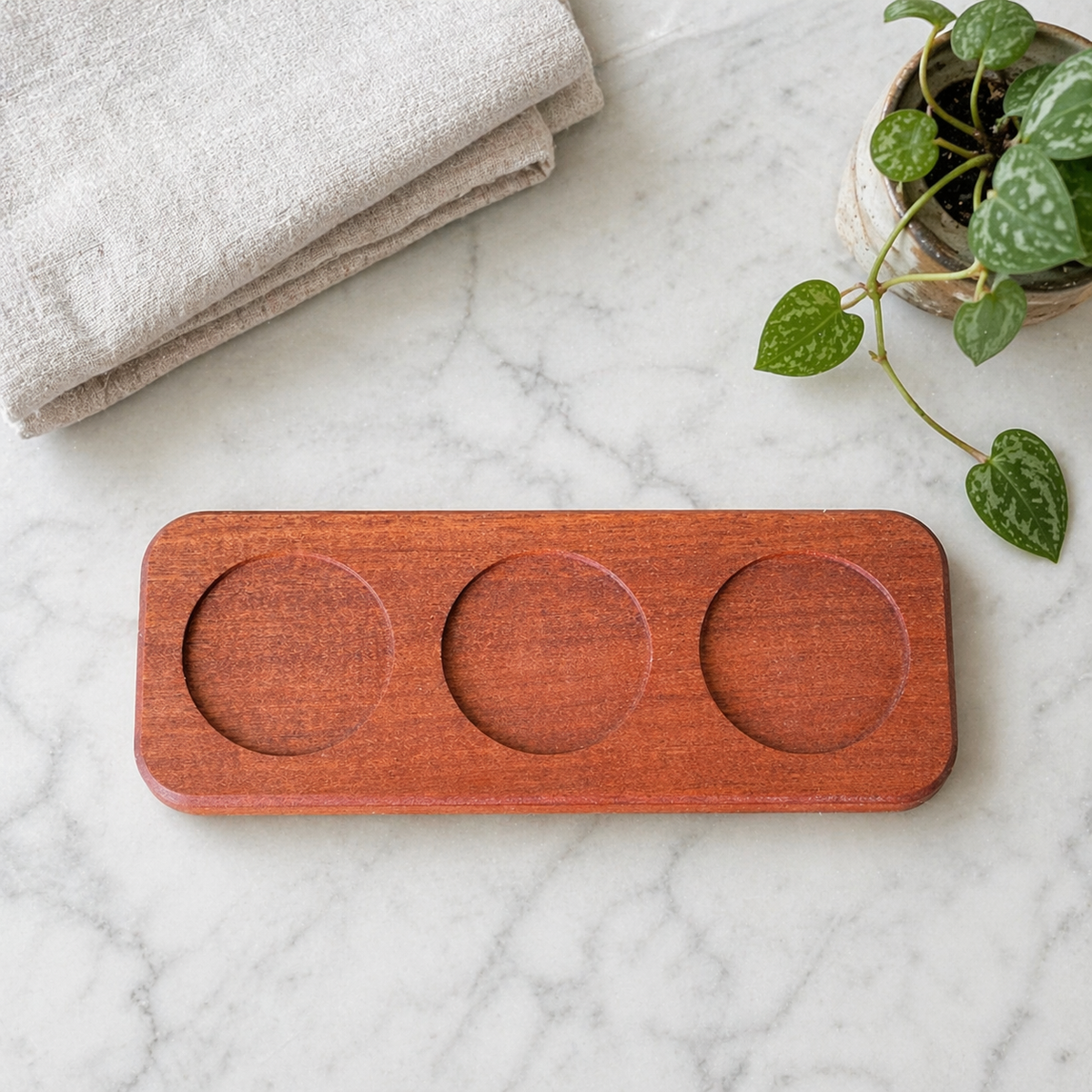 Sapele candle tray holding Emberwood & Hearth candles flush in its pockets